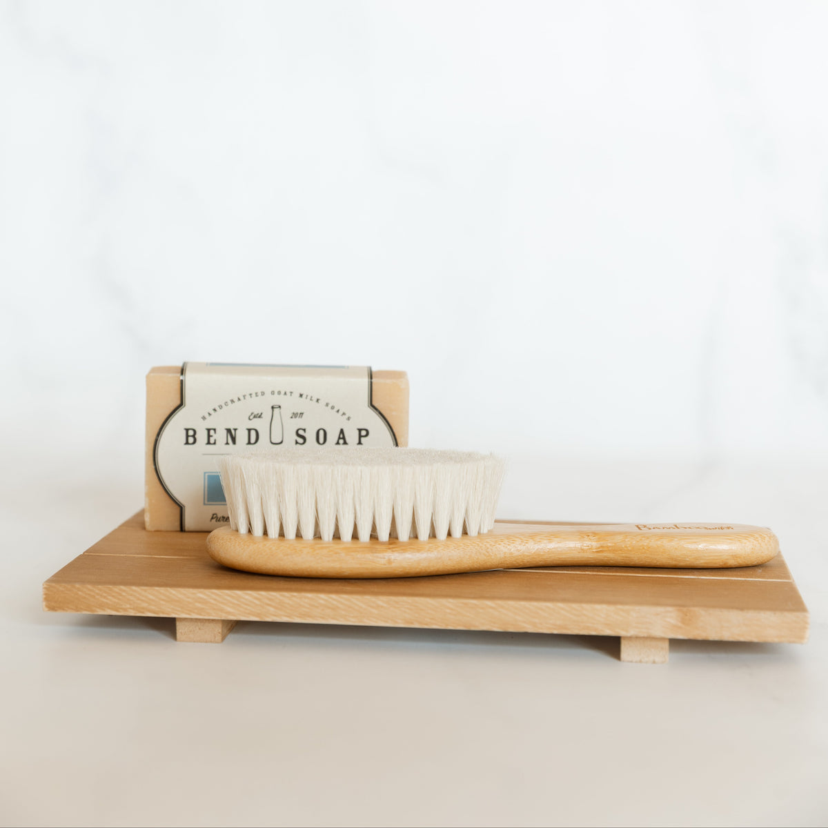 Bamboo dish brush and soap on a white background
