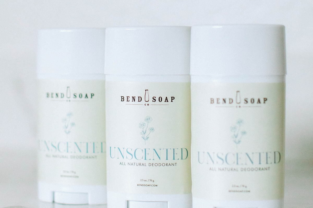 Three sticks of Bend Soap Co. Unscented All Natural Deodorant are arranged in a row against a light background, with the center stick in clear focus.