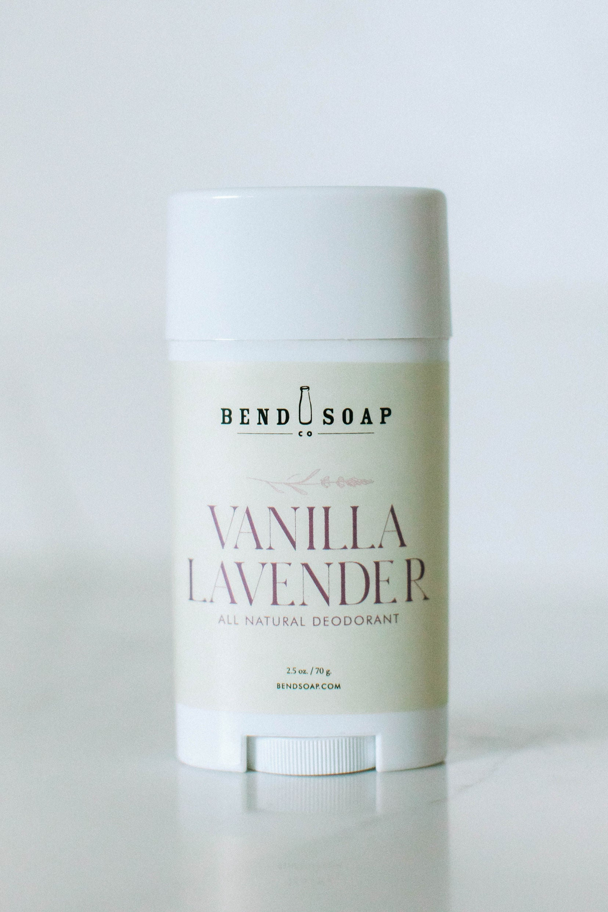 A stick of Bend Soap Co. Vanilla Lavender all natural deodorant, white container with a simple beige label, standing upright on a white background.