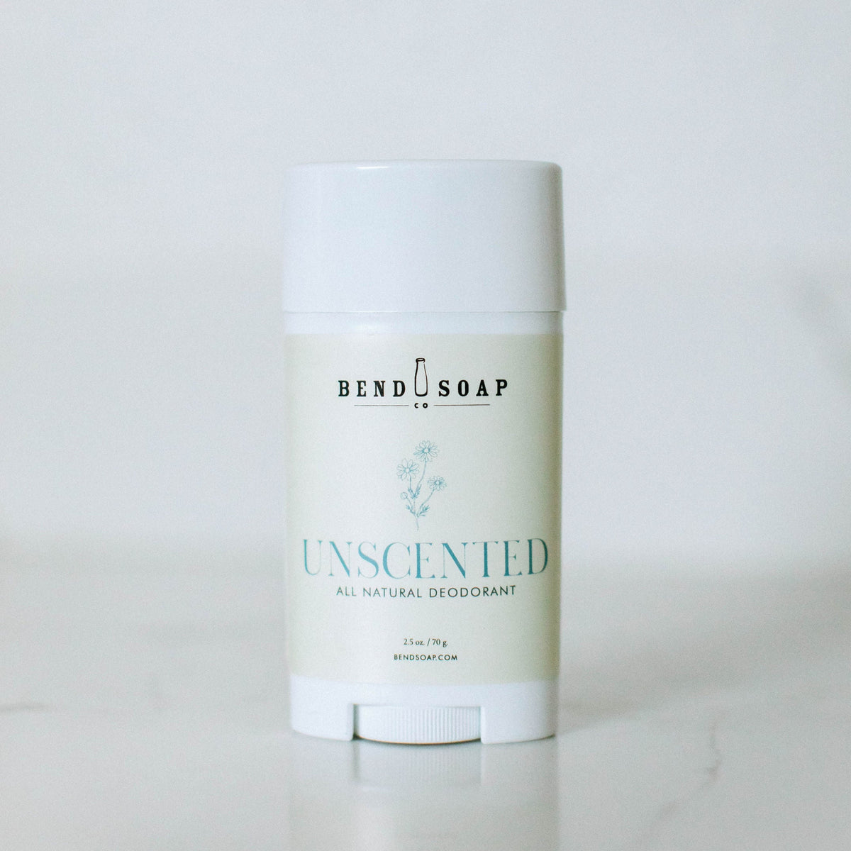 A white stick from the Magnesium Deodorant (Baking Soda Free) Variety Pack stands upright against a plain background, its label displaying minimalist text and a floral illustration to highlight gentle odor protection with magnesium hydroxide.