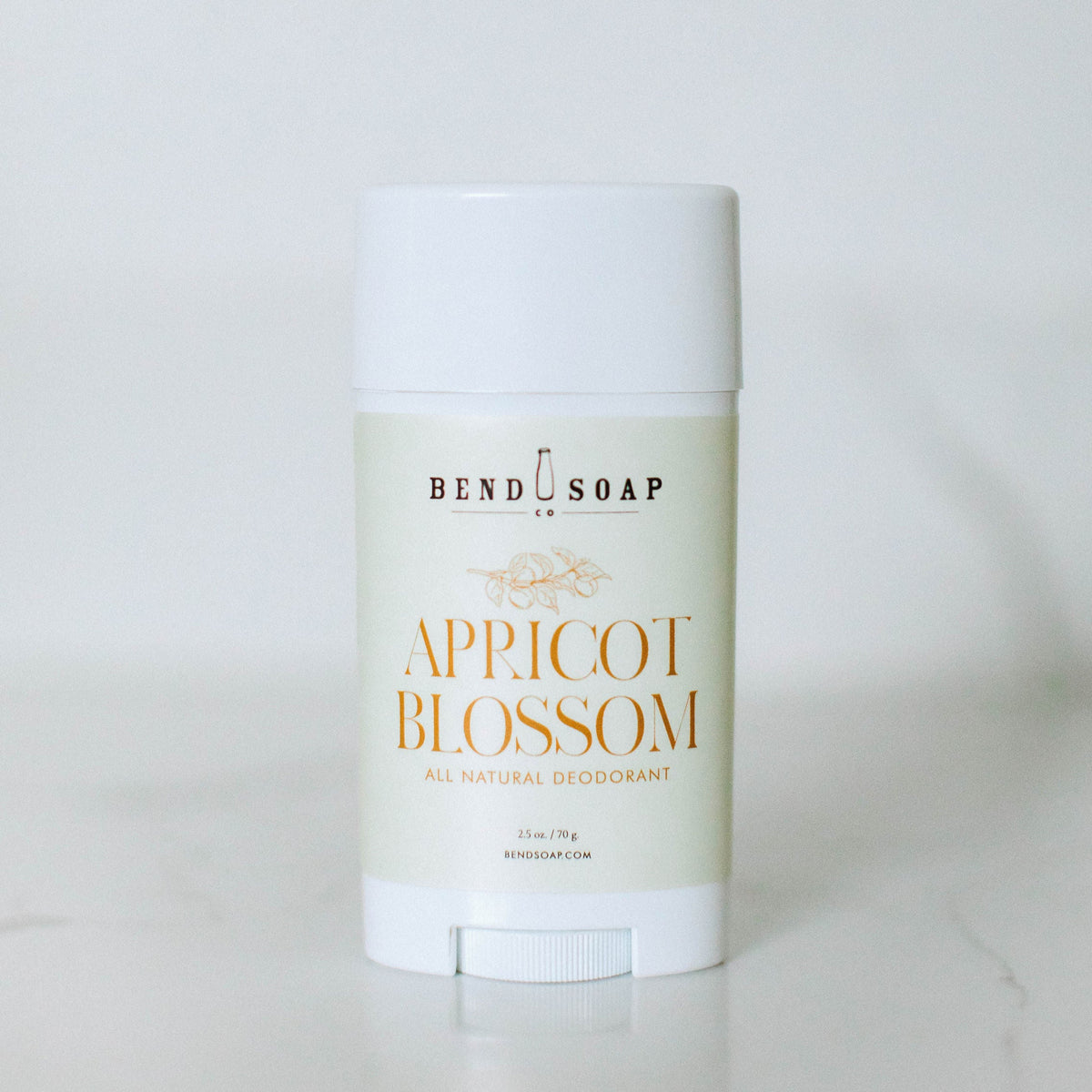 A white stick of Bend Soap Magnesium Deodorant (Baking Soda Free) Variety Pack stands upright on a light surface, featuring a simple cream-colored label and orange text for gentle, effective odor protection.